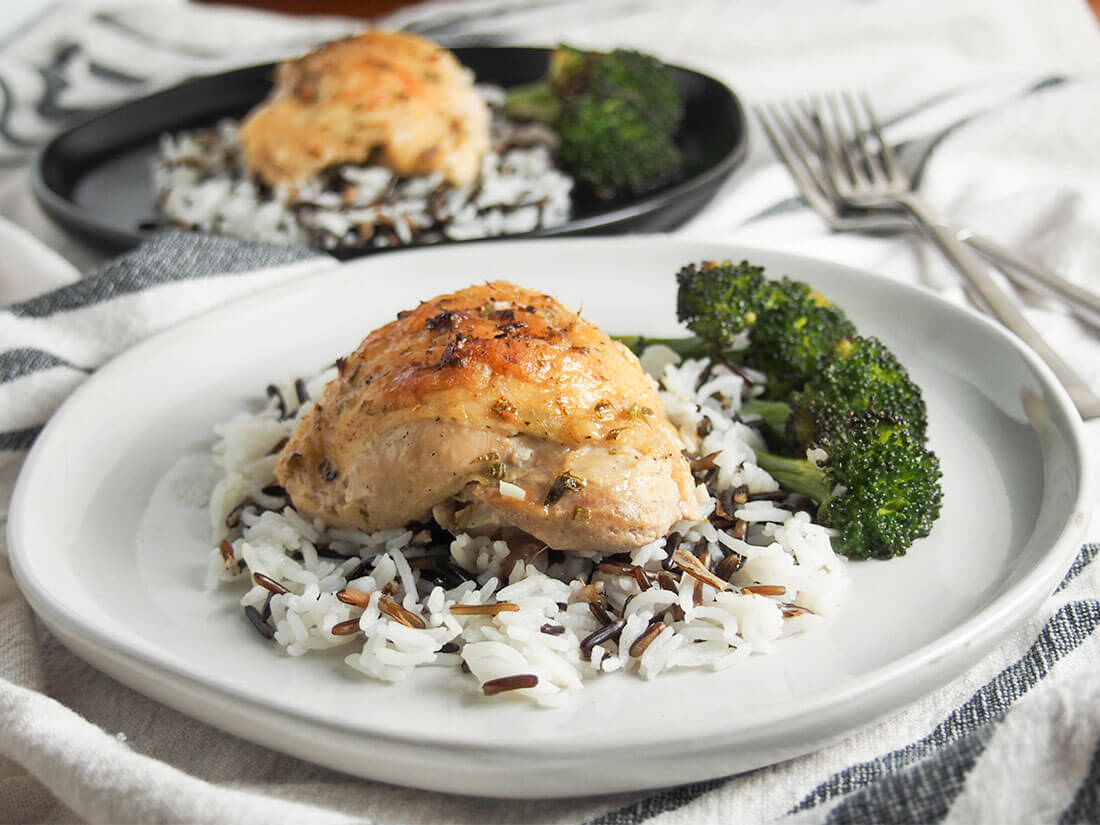 baked tarragon chicken on plate served over rice and with broccoli to side