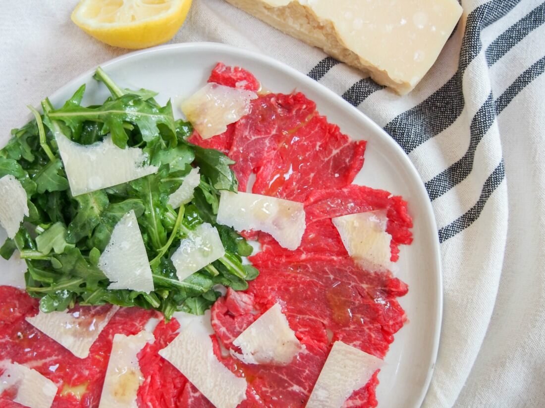 part view of plate of beef carpaccio with truffle vinaigrette