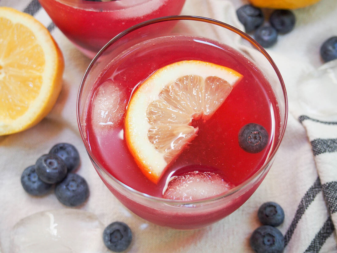 blueberry lemonade in glass with slice of lemon floating on top