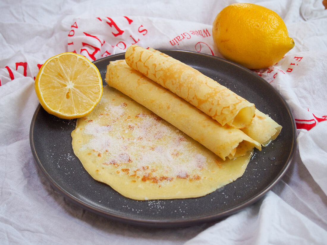 British pancakes rolled in small stack with lemon to side