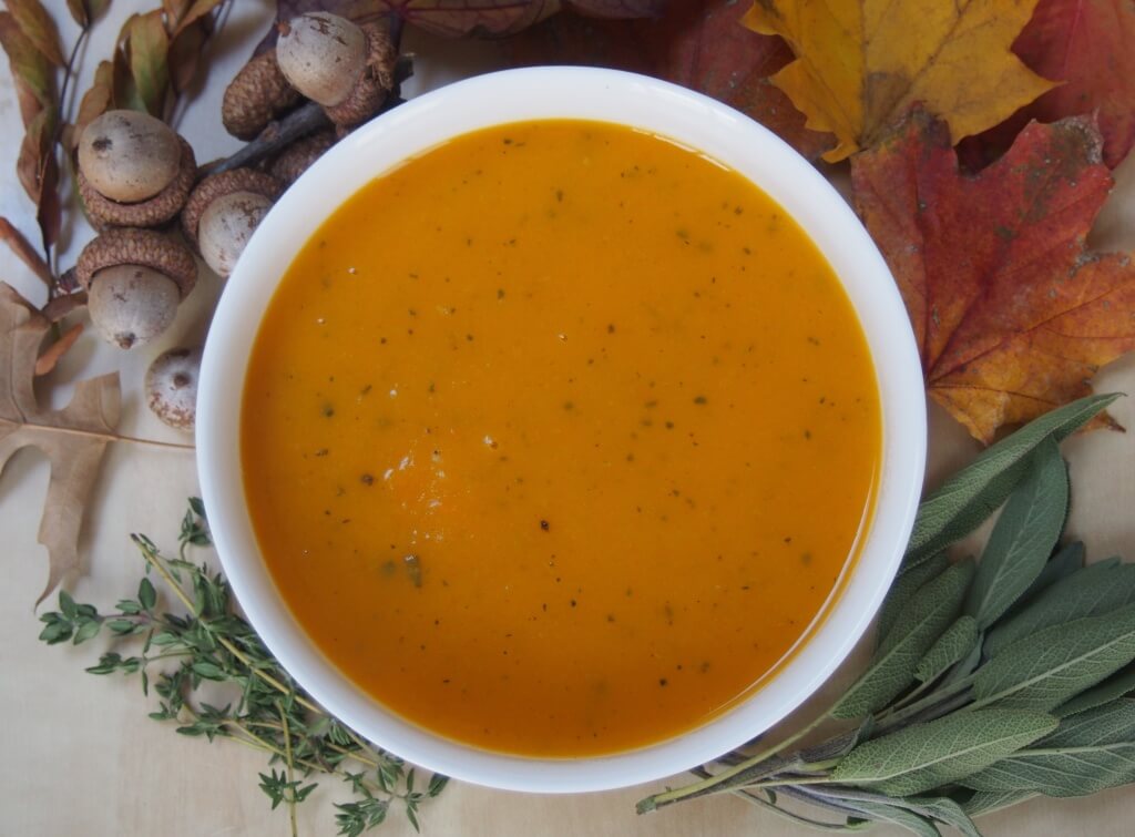 Bowl of butternut squash soup with apple, sage and thyme from above