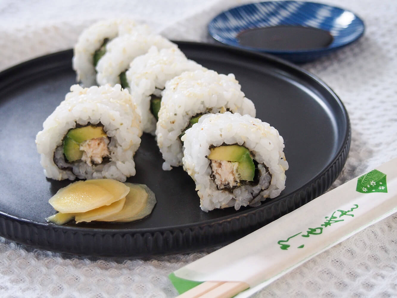 California roll with side of pickled ginger and soy behind