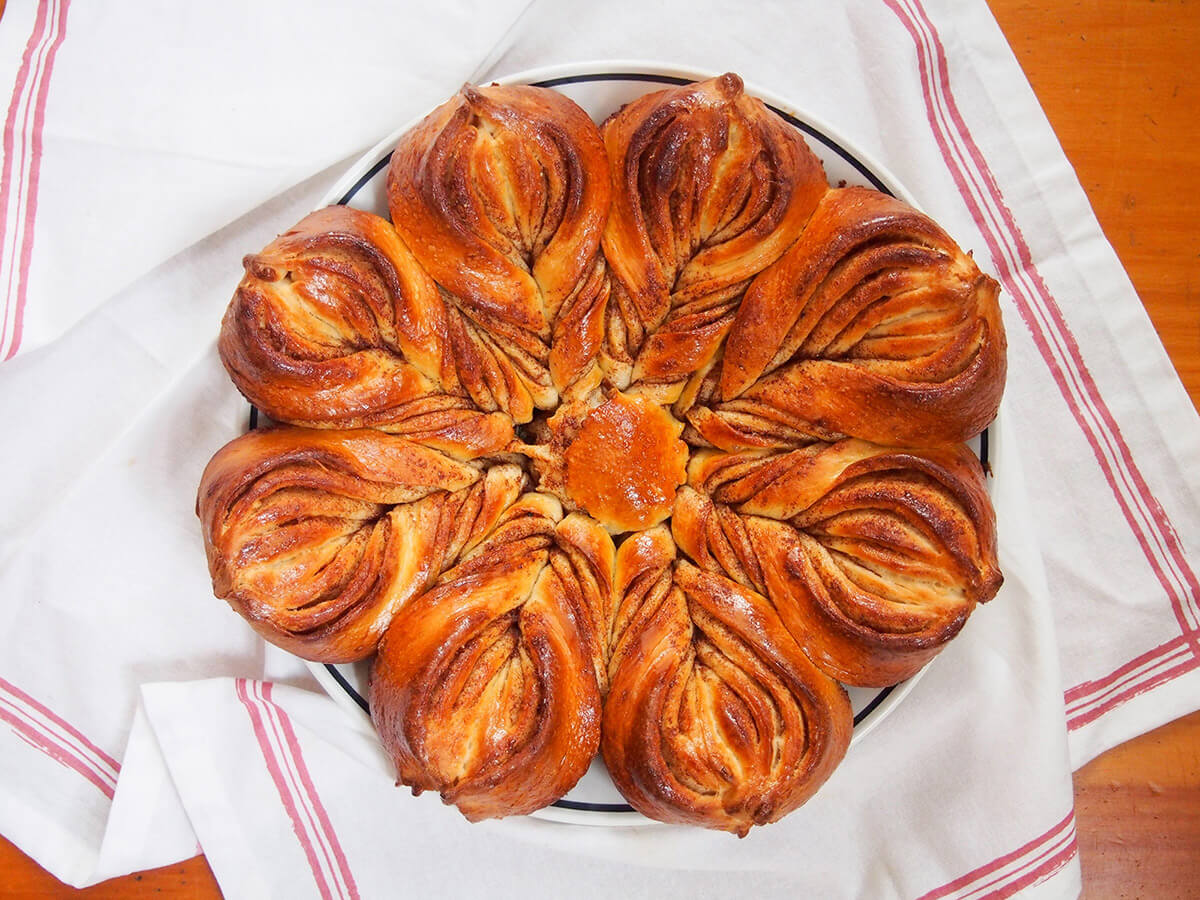 whole cinnamon star bread on plate on top of white cloth