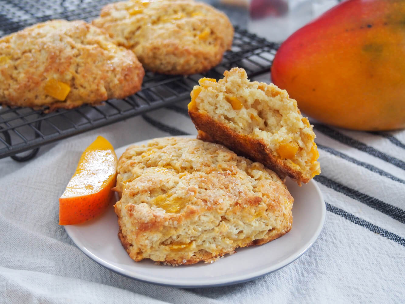 Coconut mango scones with one whole and one split on plate