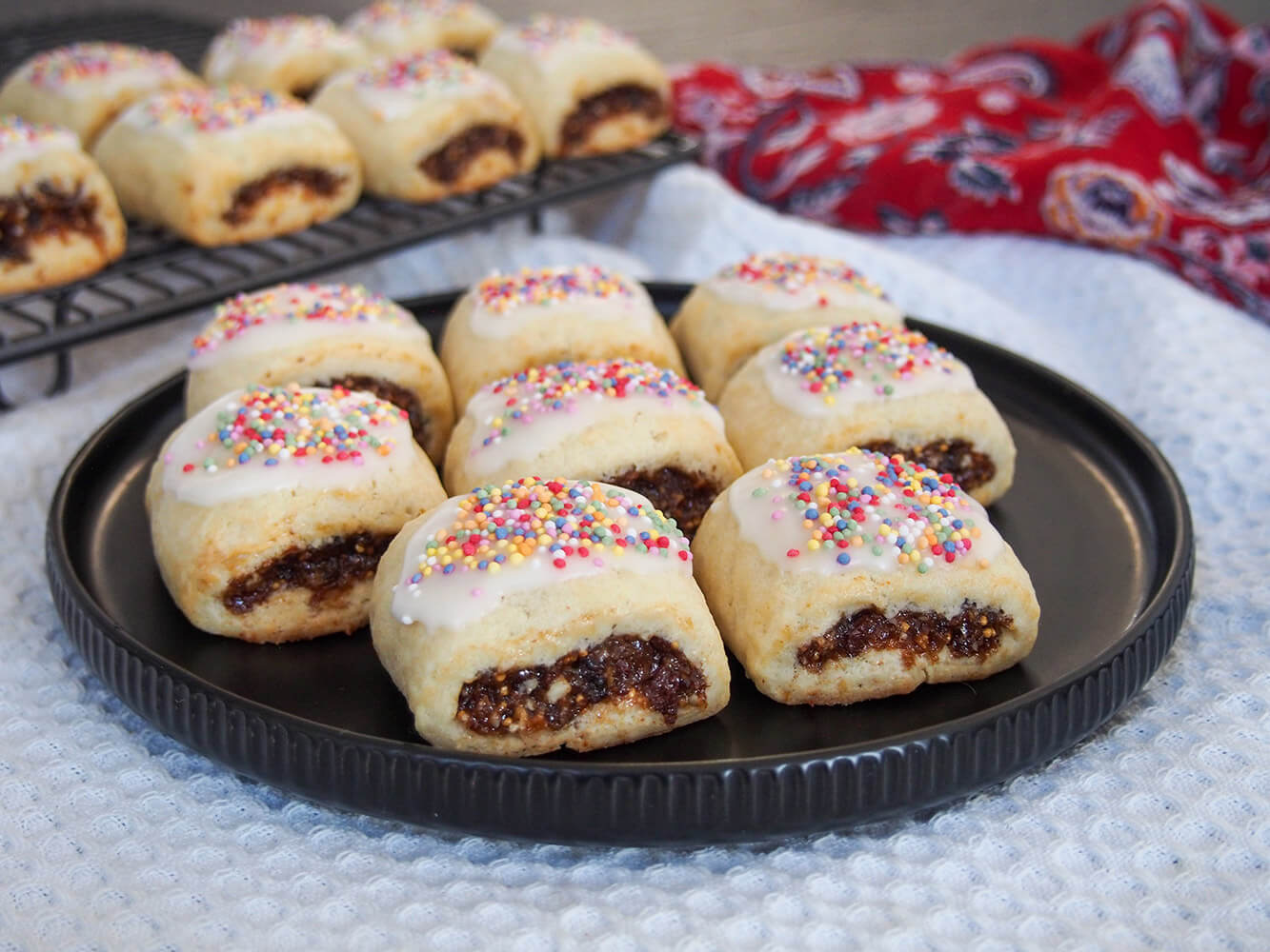 cucidati Italian fig cookies on plate with more on rack behind