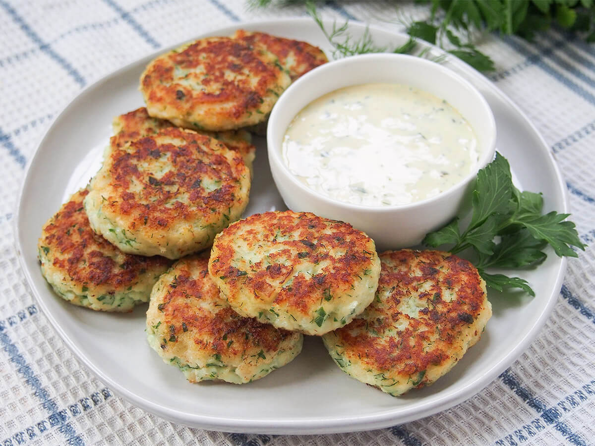 plate of fiskefrikadeller Danish fish cakes with remoulade in bowl behind