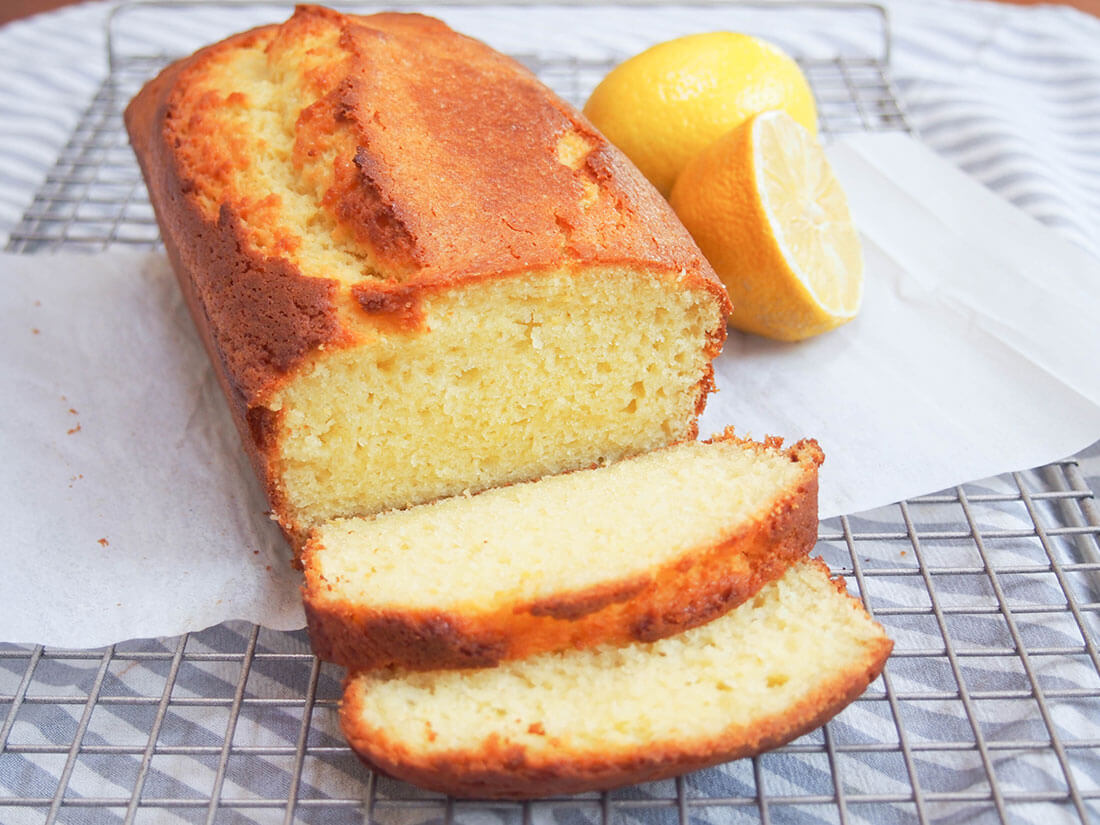 French lemon yogurt cake with two slices cut from loaf falling forward