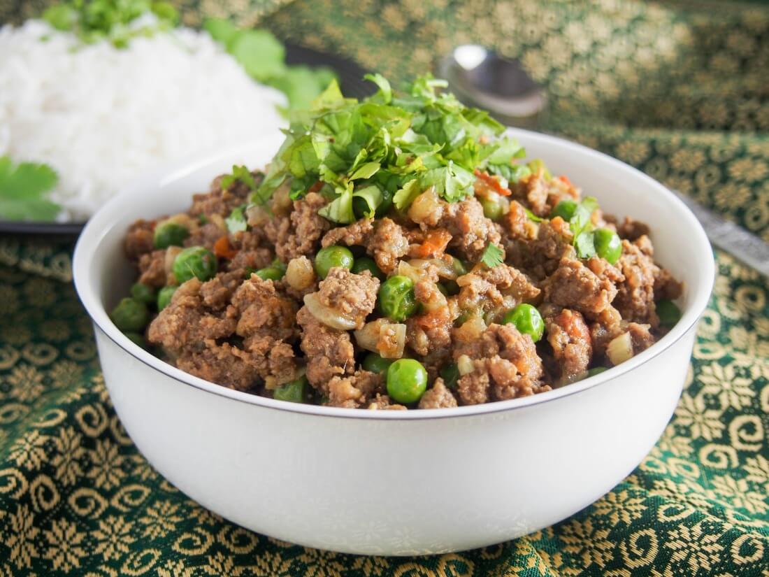 bowl of keema curry (keema matar) garnished with cilantro