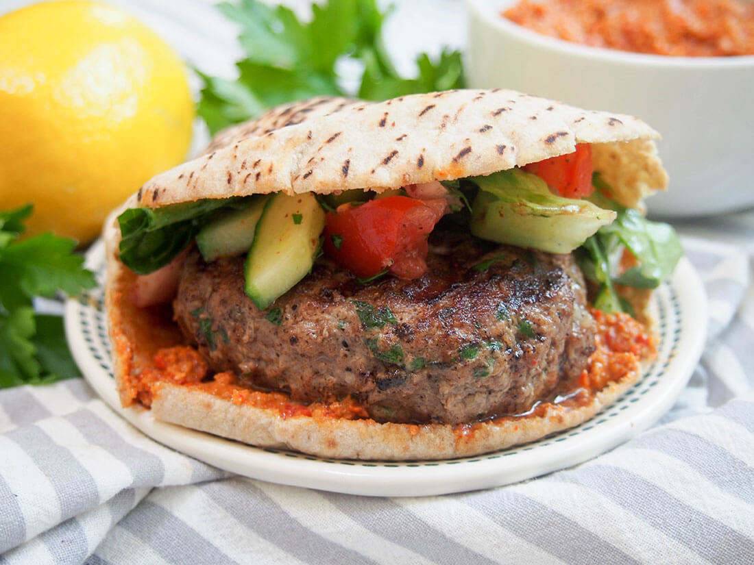 lamb kofte burger with muhammara and lemon in background