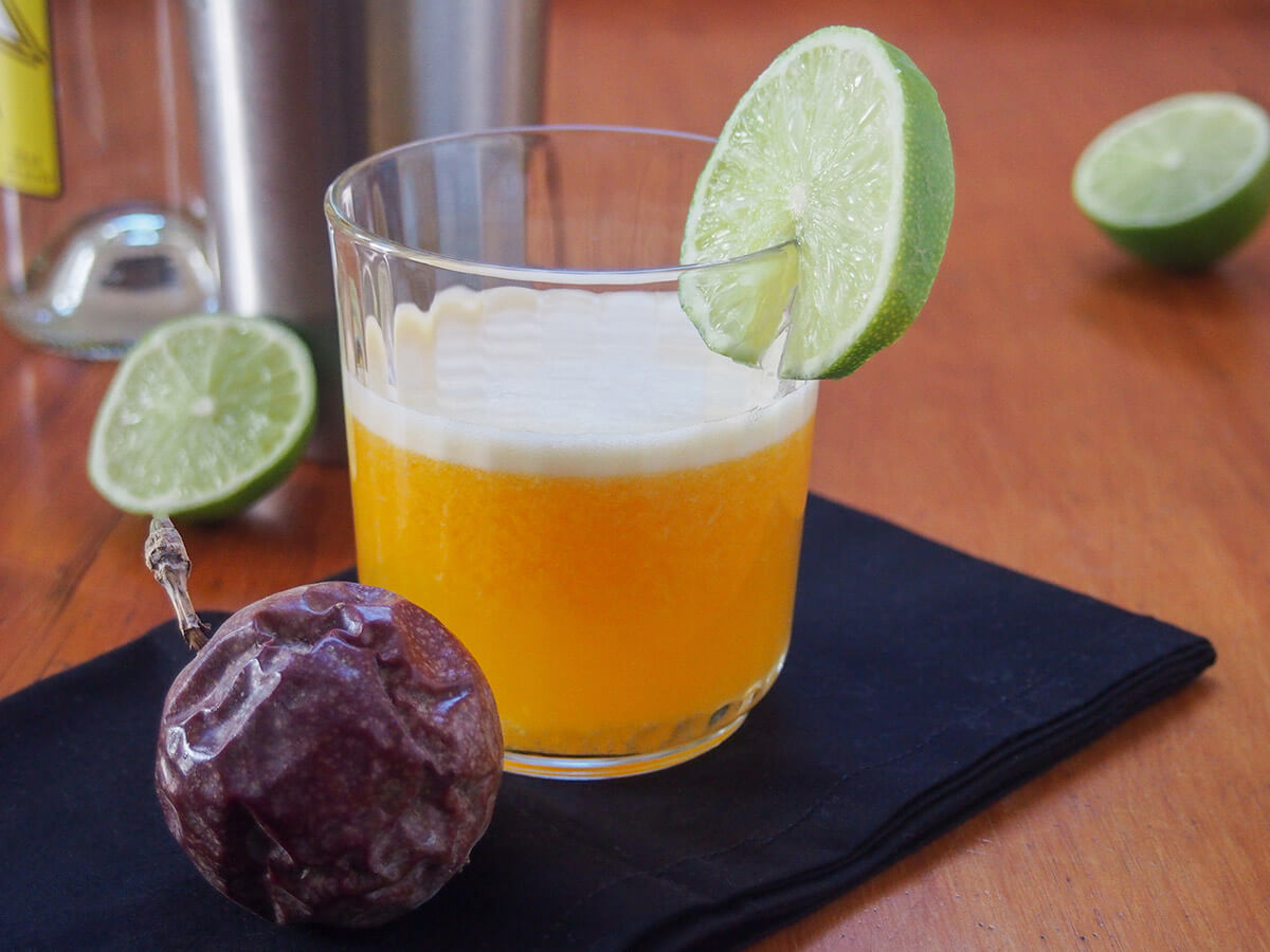 glass of maracuya sour with part lime behind