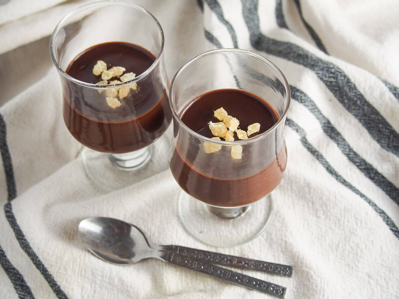 two glasses of no bake chocolate custard with ginger with two spoons in front