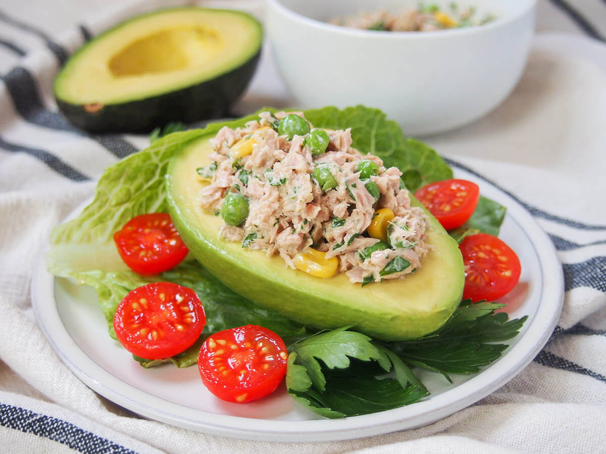 palta rellena, tuna stuffed avocado, with tomatoes around on plate