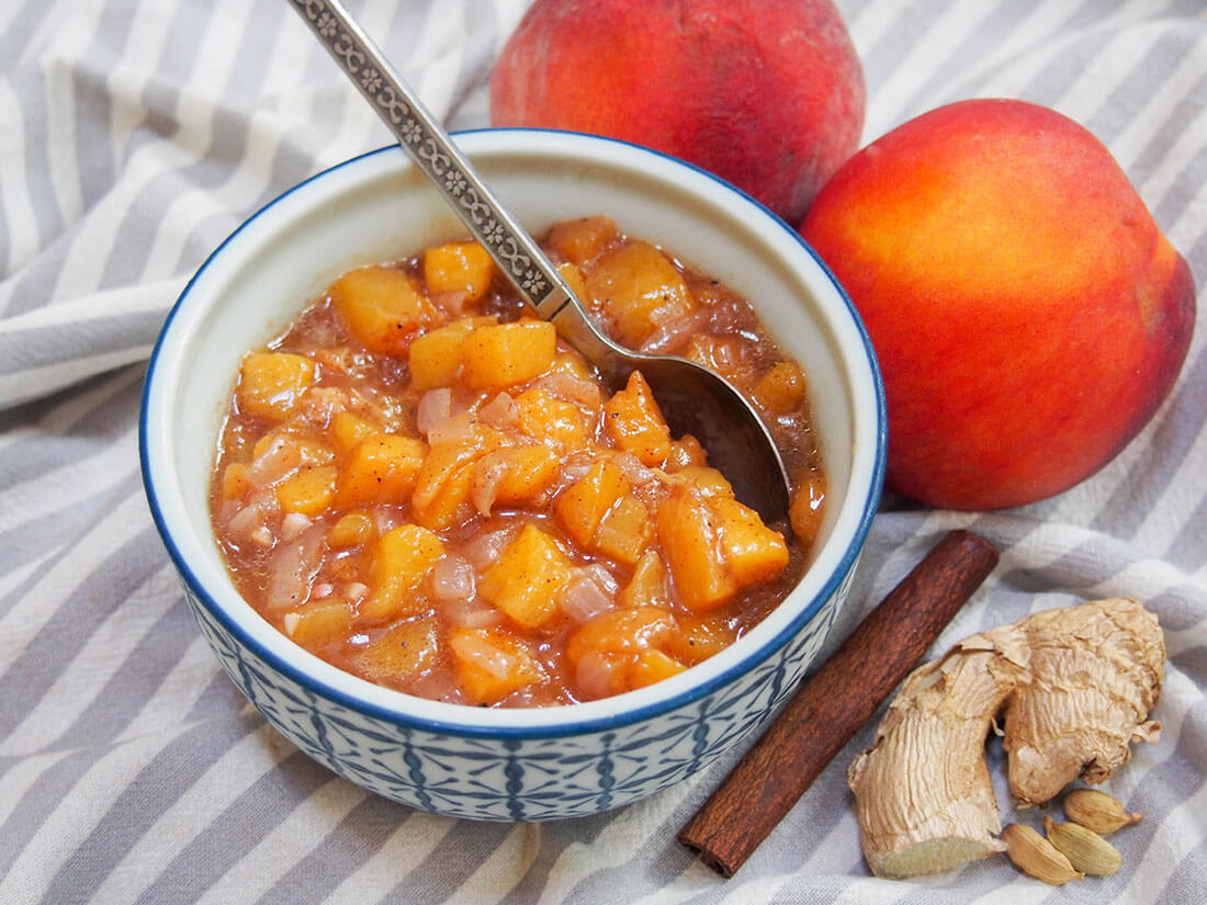 peach chutney in bowl with peach and spices to side