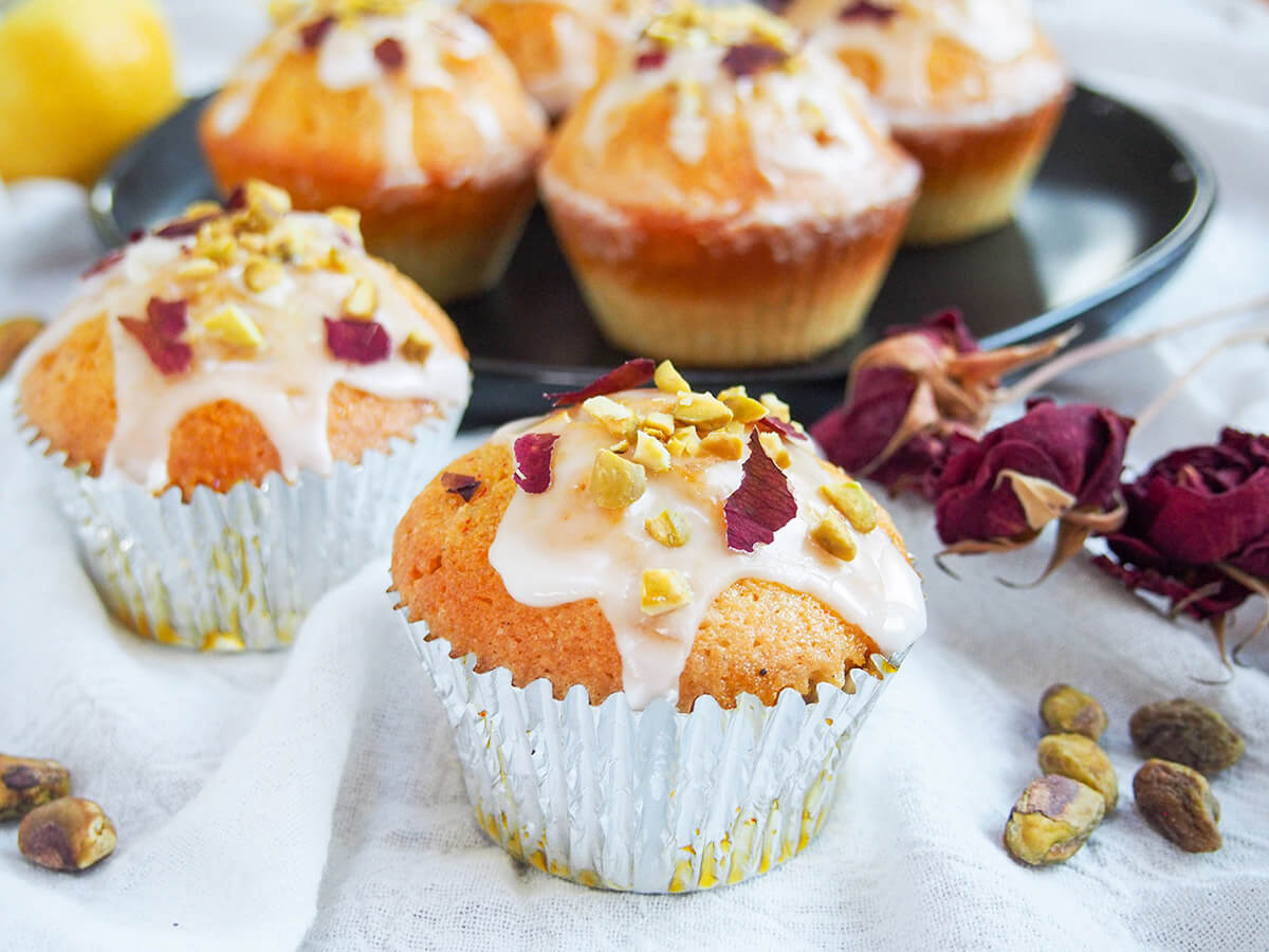 two Persian love cake cupcakes in casing with more on plate behind