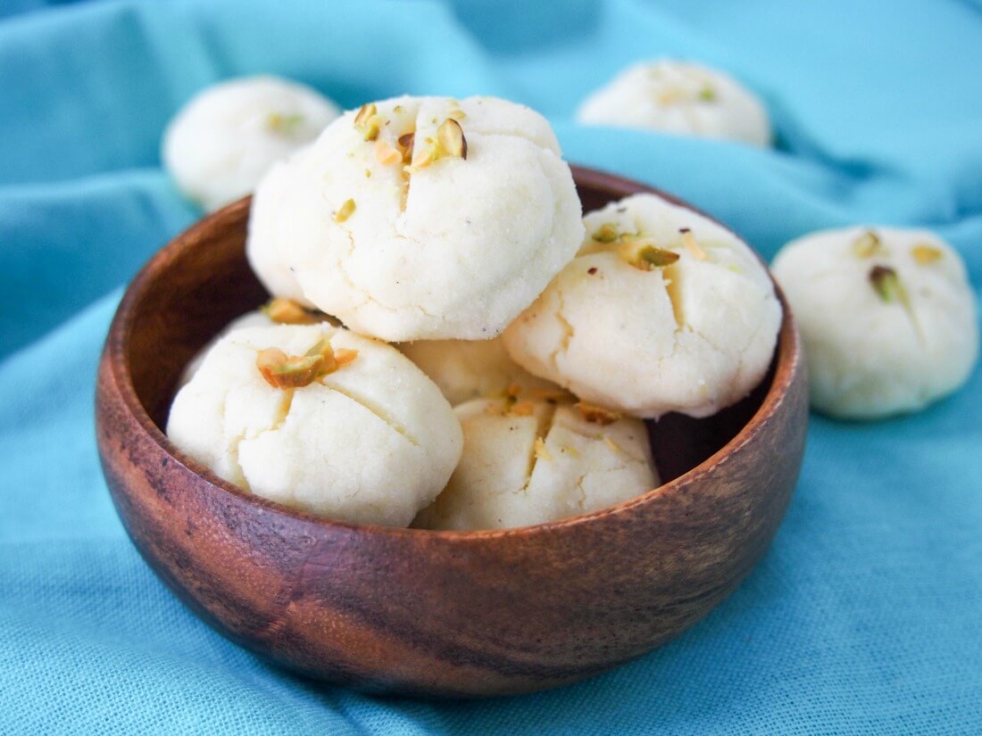 small bowl of Persian rice cookies (nan-e berenji) with couple more behind