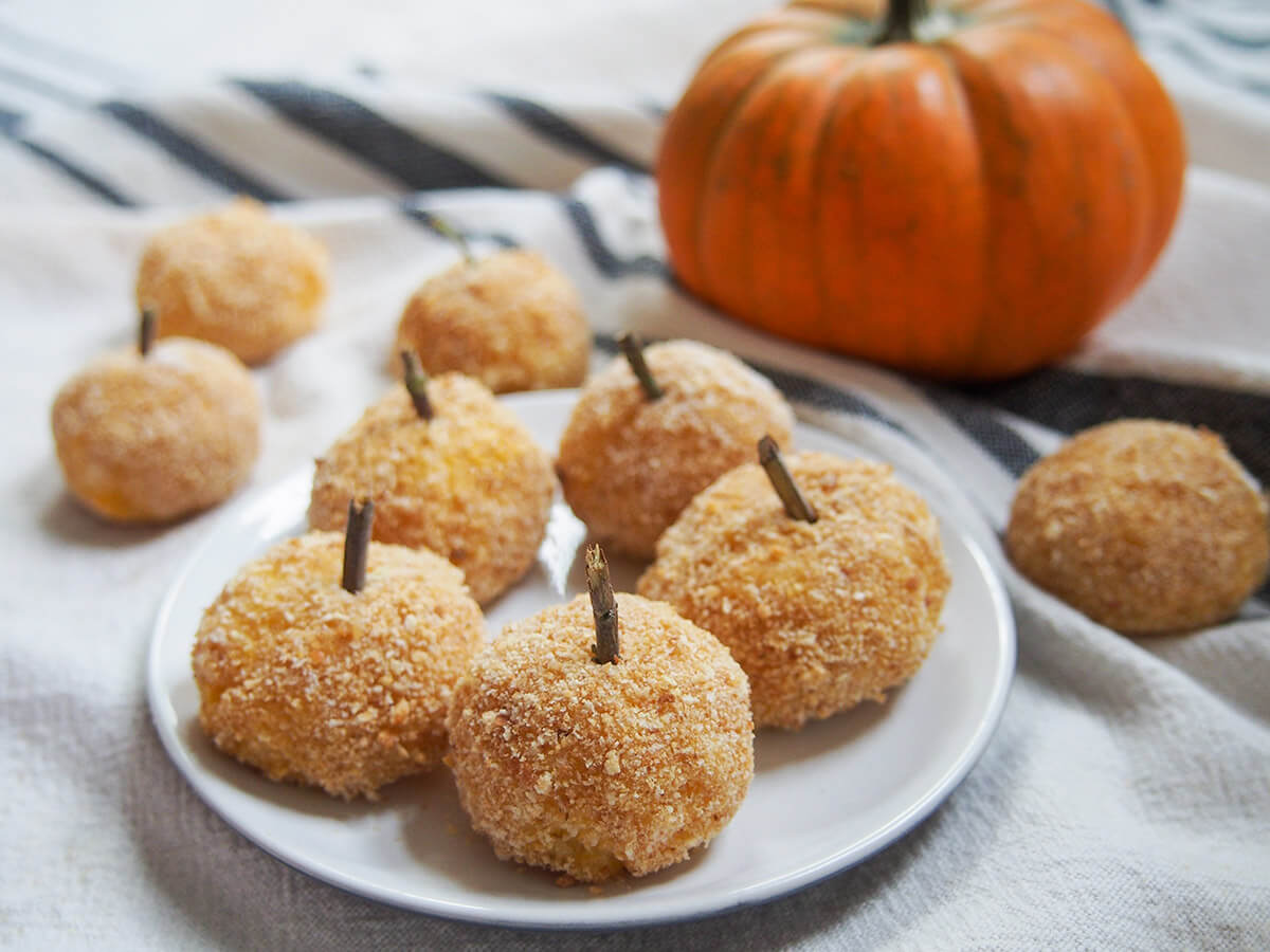 plate of pumpkin arancini with mini pumpkin behind