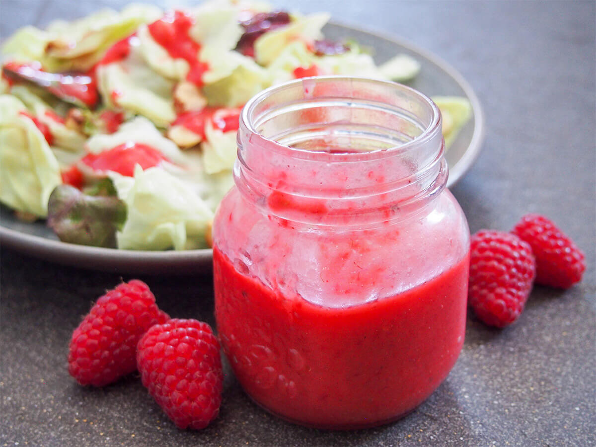 jar of raspberry vinaigrette with raspberries to side