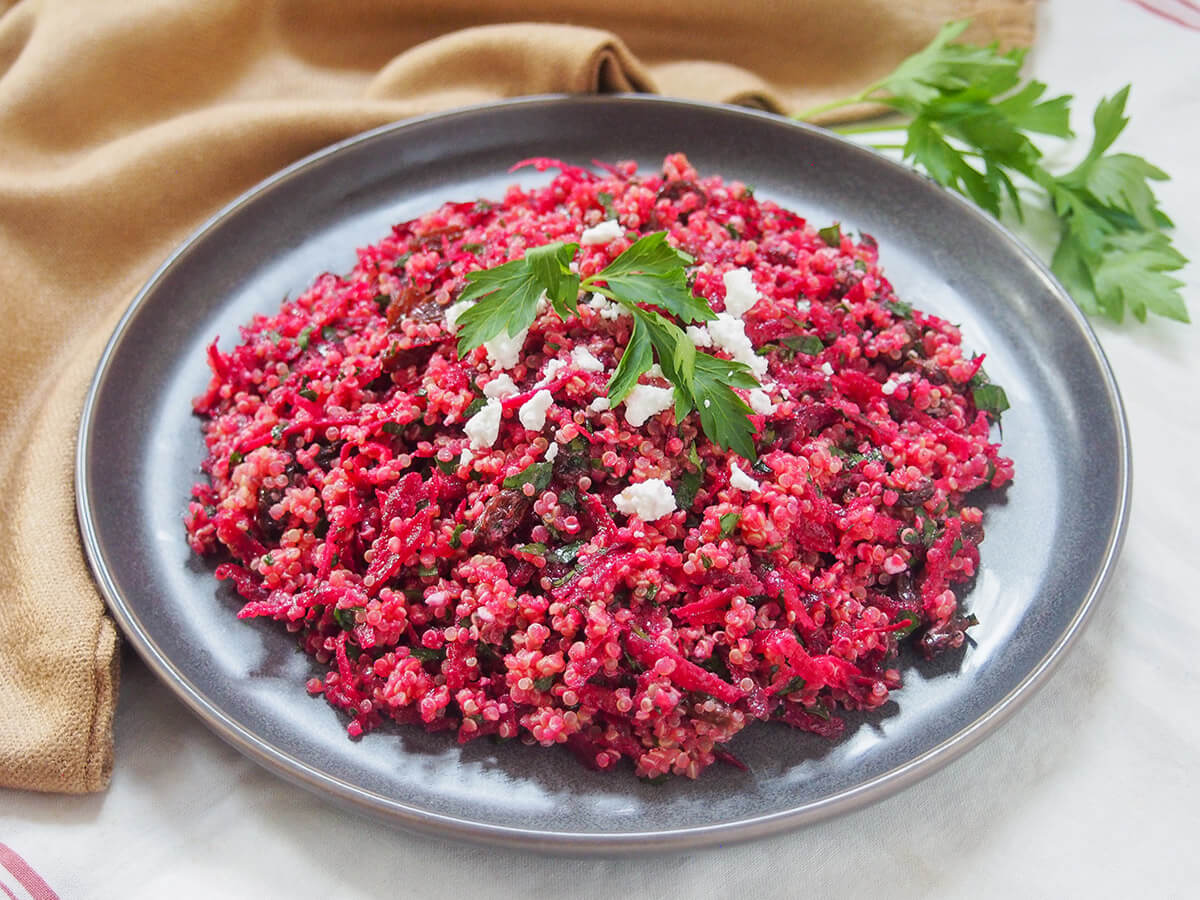 plate of raw beet quinoa salad garnished with parsley