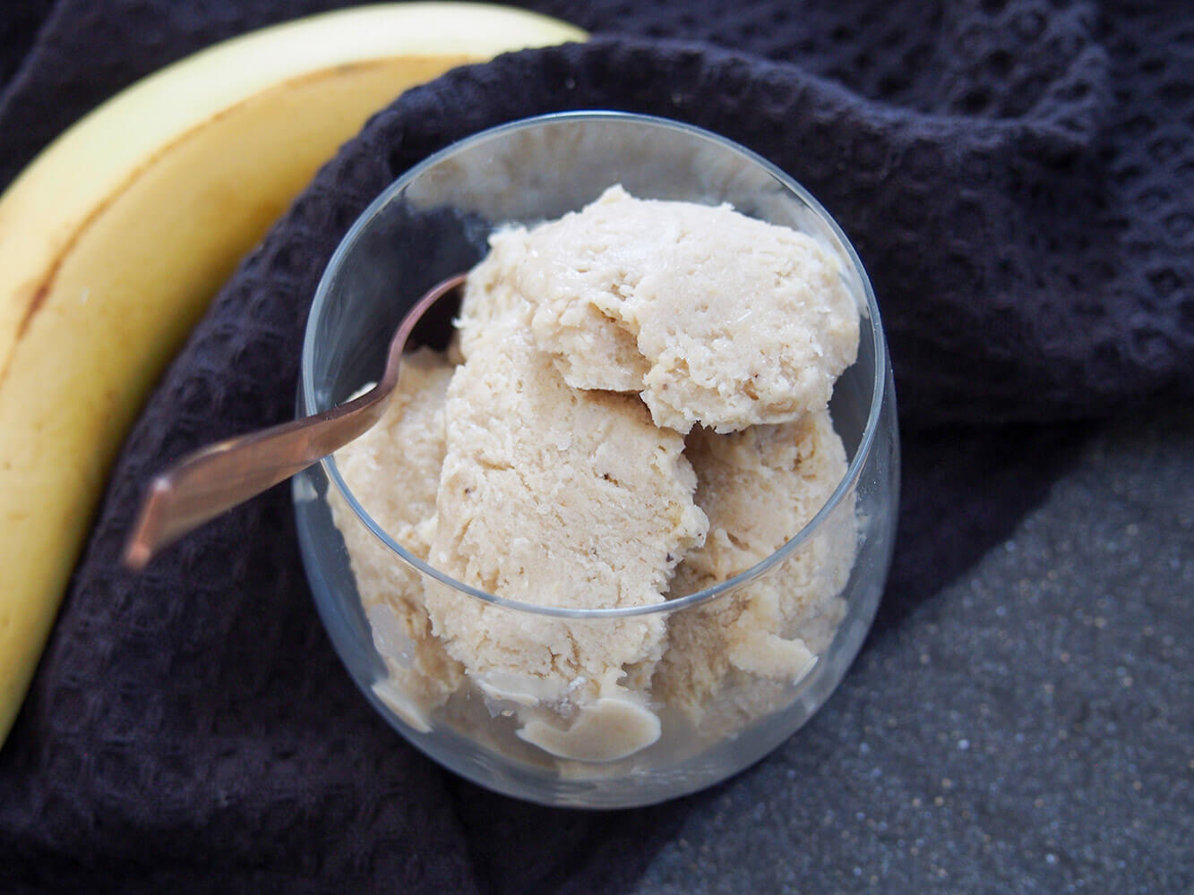 Roasted banana ice cream in glass with spoon in side of glass