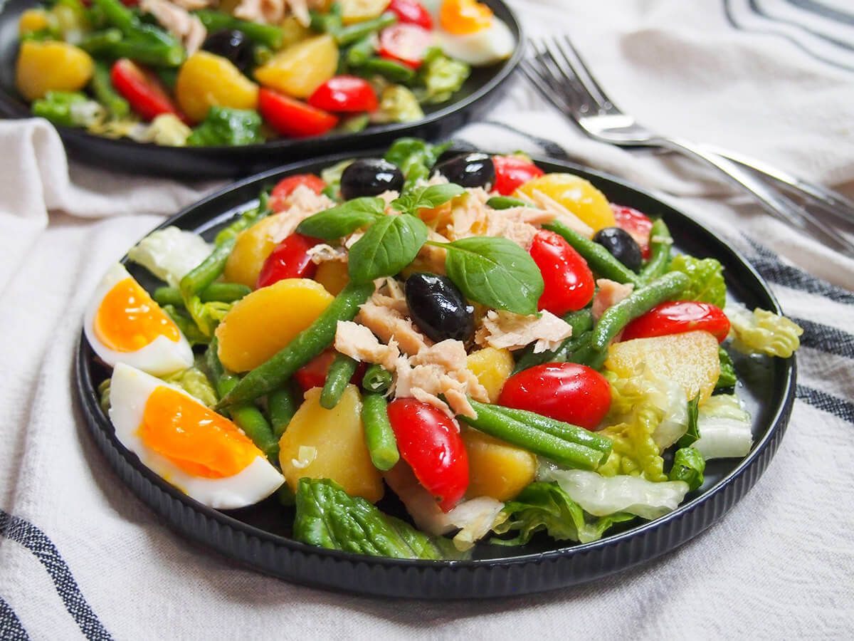 plate of salade Nicoise garnished with basil