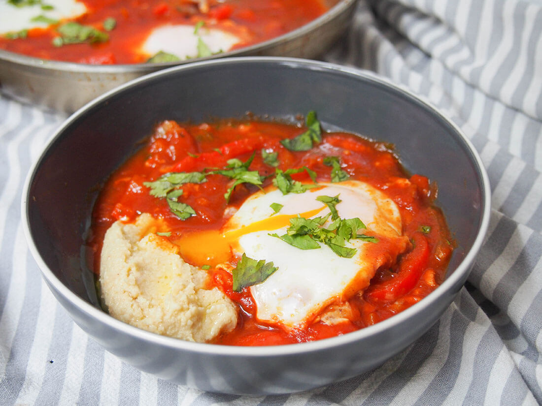 shakshuka hummus in a bowl with egg yolk running into hummus