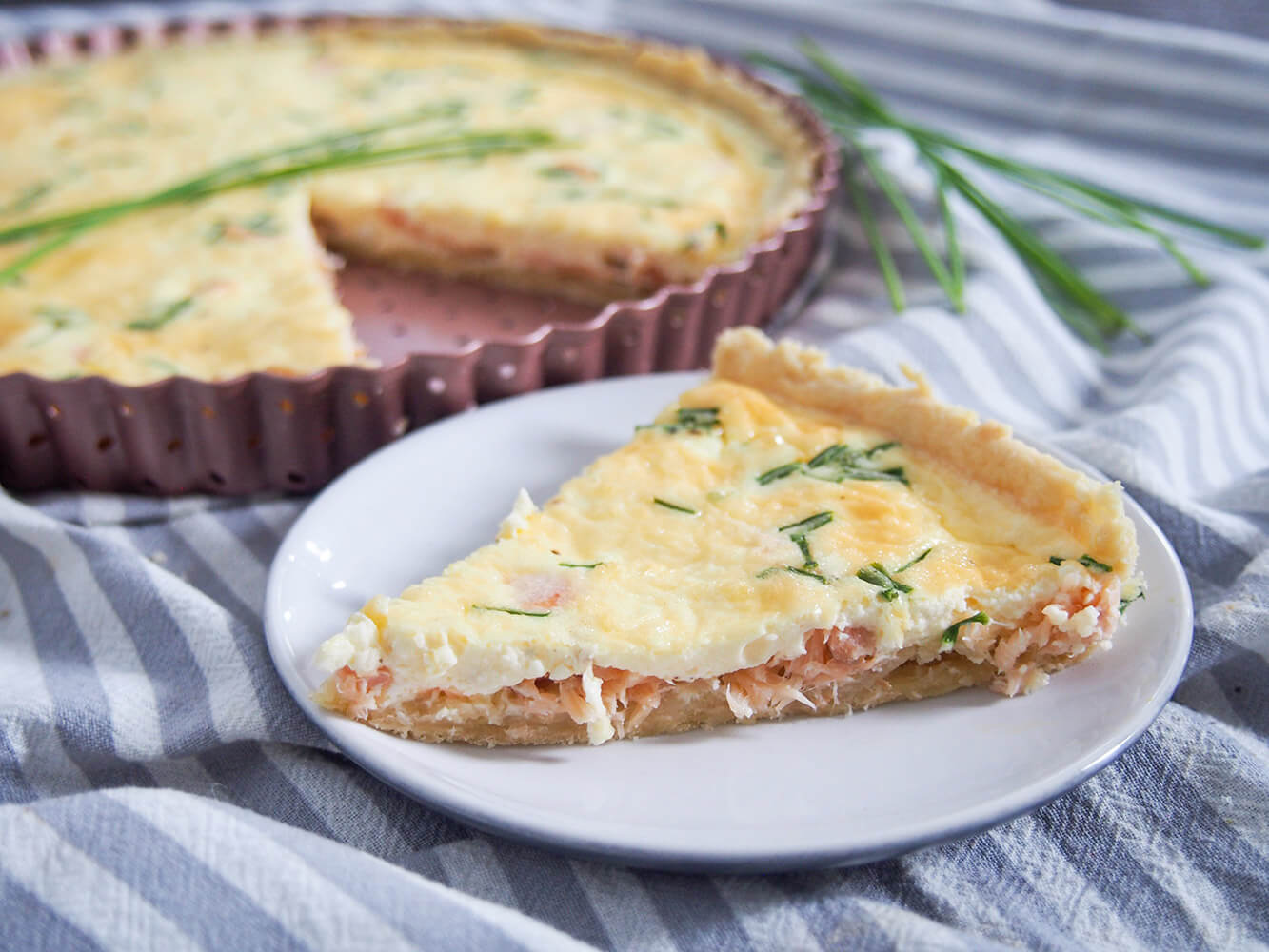 smoked salmon quiche with slice on plate in front