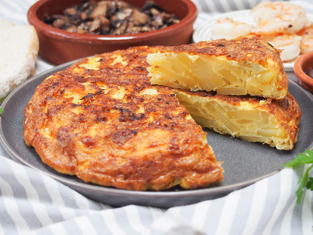 Spanish tortilla (tortilla Española) with a slice cut out and on top