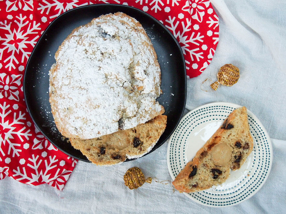 traditional German stollen with dried plums with slice on plate to side