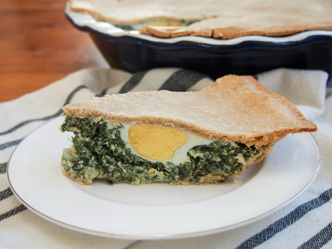 slice of torta pascualina spinach ricotta pie showing egg inside