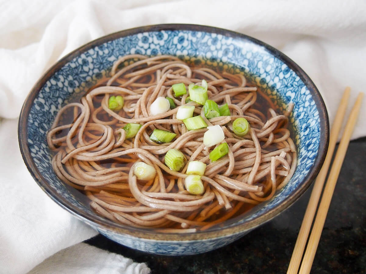 Bowl of Toshikoshi soba noodles with chopsticks to side