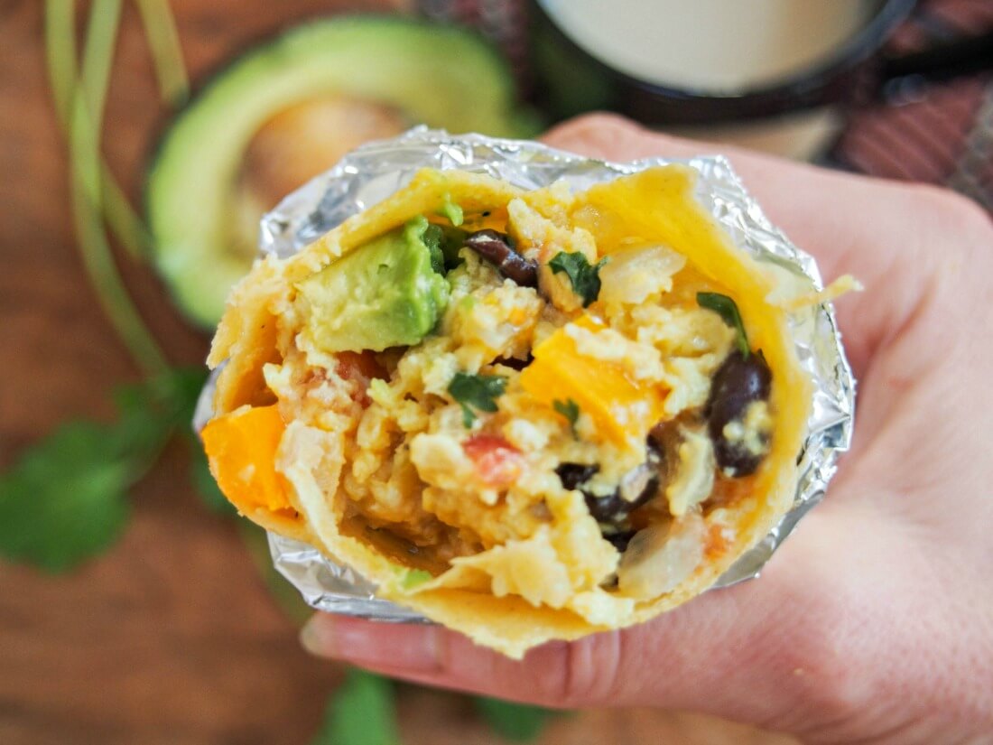 vegetarian breakfast burrito held in hand